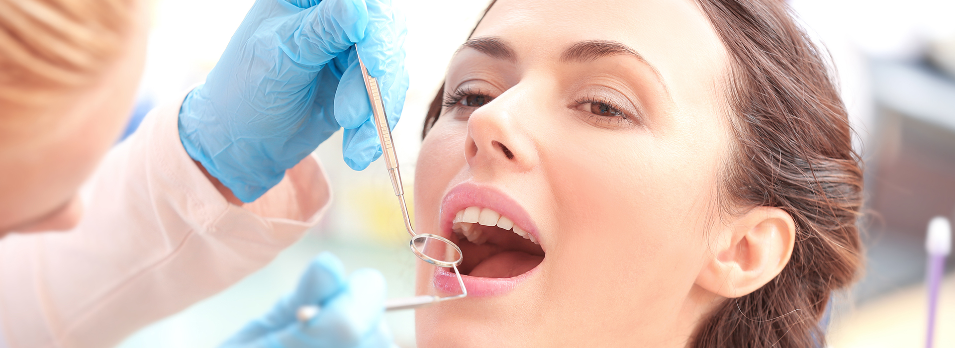 A woman receiving dental care, with a dentist performing the procedure.